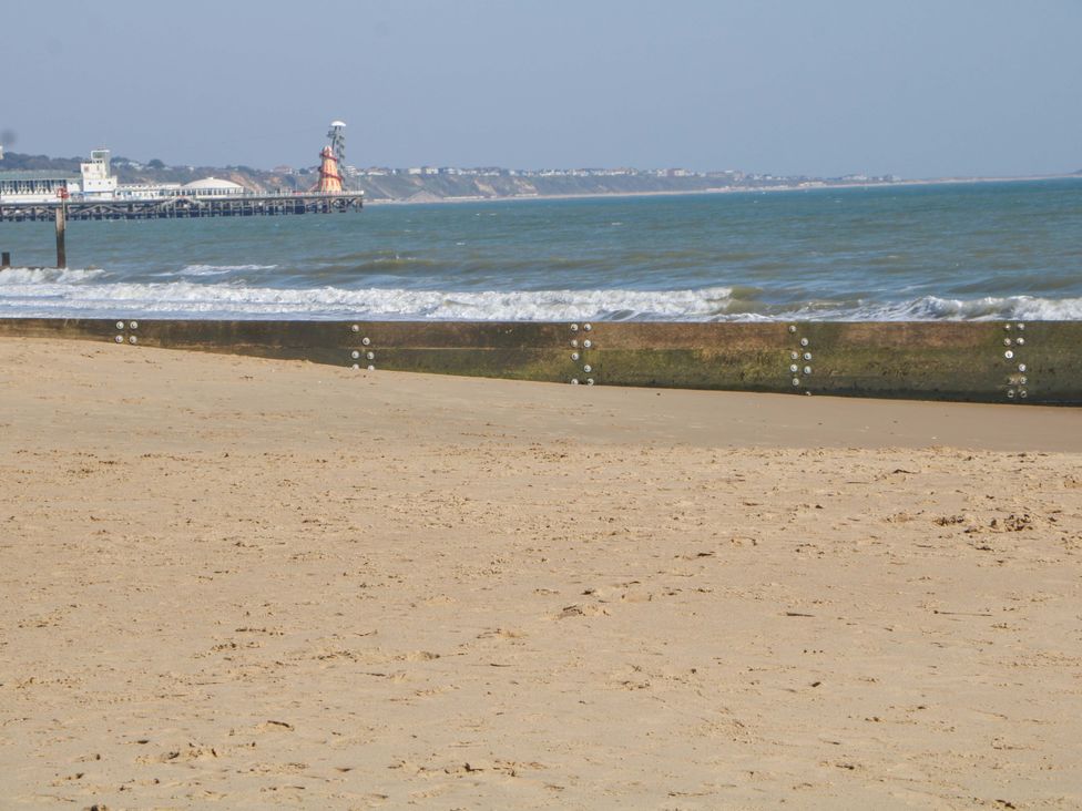 A beach with sand and water at Shell Cottage in Bournemouth
