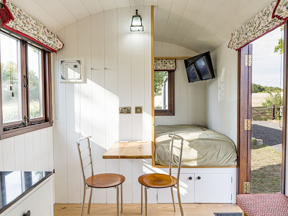 A bedroom with a bed and table at No 1 The Orchard Upton Warren