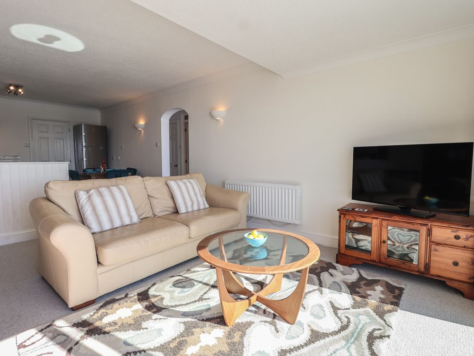 A living room with a sofa and television stand at 6 Avon Quillet Bigbury-On-Sea