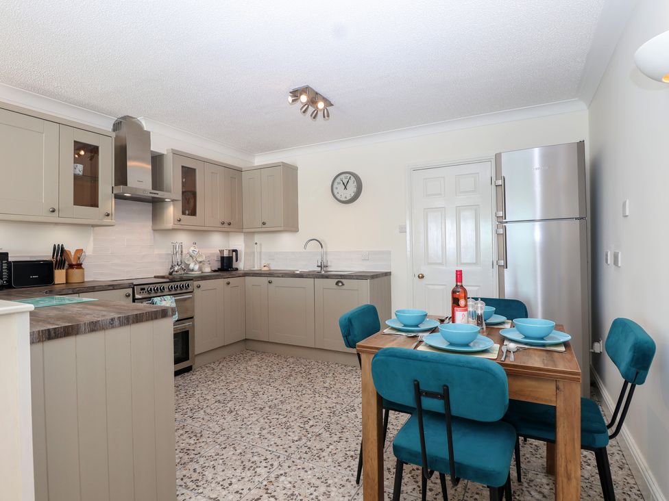 A kitchen with appliances and dining area at 6 Avon Quillet Bigbury-On-Sea