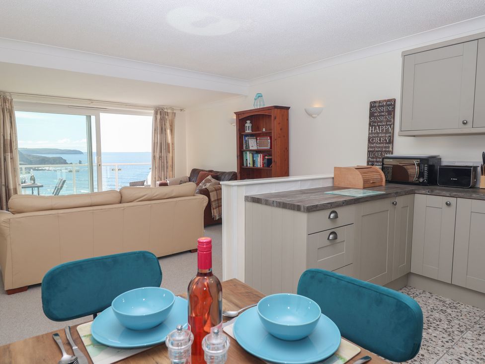 A living room with a dining area and kitchen at 6 Avon Quillet in Bigbury-On-Sea