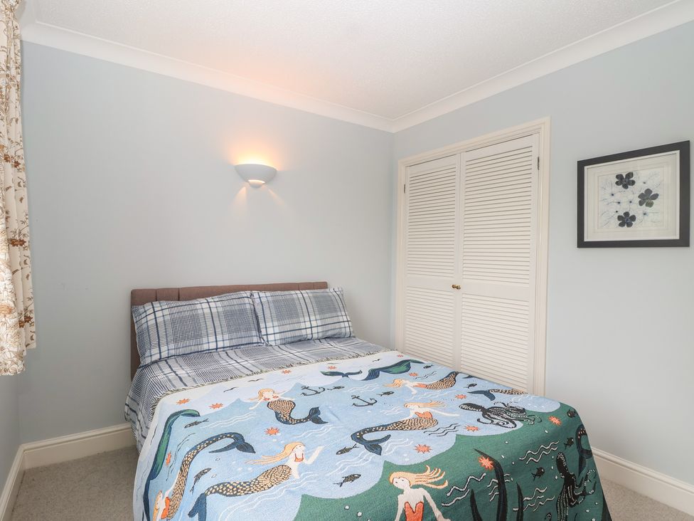 A bedroom with a bed and closet at 6 Avon Quillet Bigbury-On-Sea