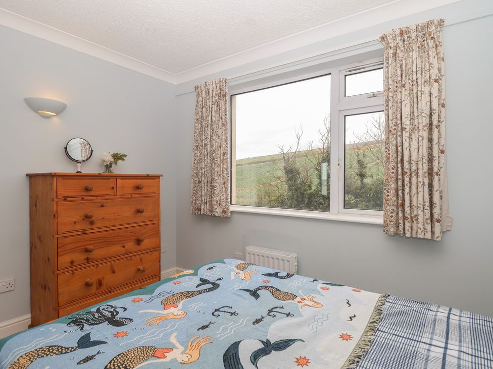 A bedroom with a bed and dresser at 6 Avon Quillet Bigbury-On-Sea