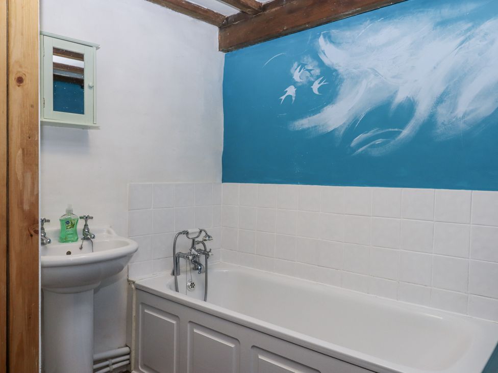 A bathroom with a bathtub and sink at Swallows Nest in Widecombe-in-the-Moor near Postbridge