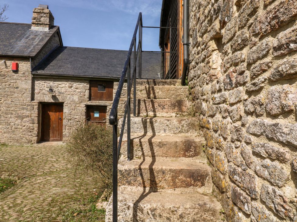 A stone path with stairs leading to a door at Swallows Nest in Widecombe-in-the-Moor near Postbridge