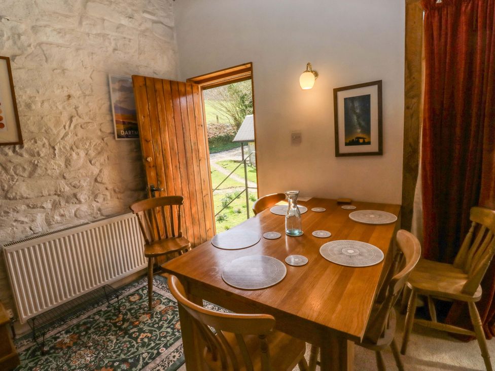 A dining room with a table and chairs at Swallows Nest in Widecombe-in-the-Moor near Postbridge
