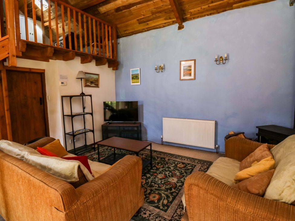 A living room with a sofa, coffee table and television at Swallows Nest in Widecombe-in-the-Moor near Postbridge