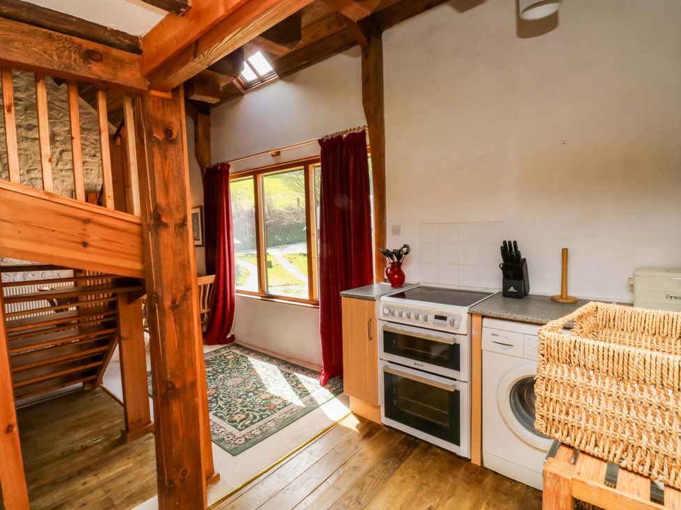 A kitchen area with a window and staircase at Swallows Nest Widecombe-in-the-Moor near Postbridge
