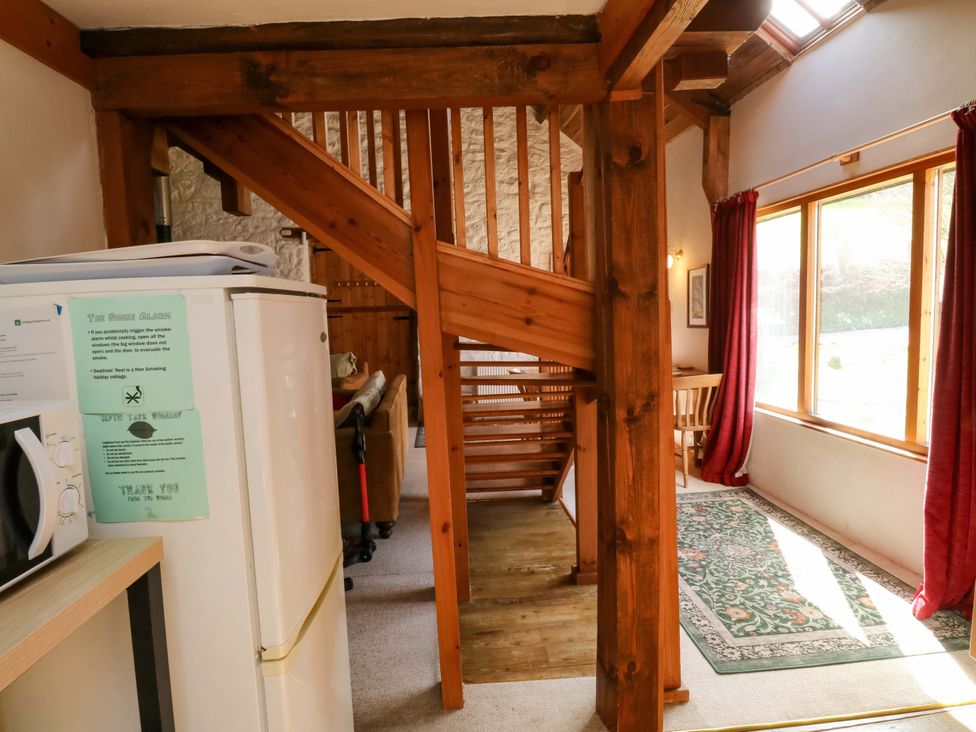 A living room with a staircase and furniture at Swallows Nest in Widecombe-in-the-Moor near Postbridge