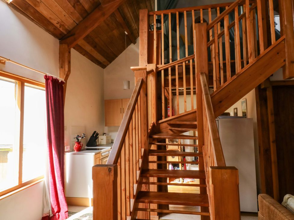 A kitchen with a staircase and window at Swallows Nest Widecombe-in-the-Moor near Postbridge