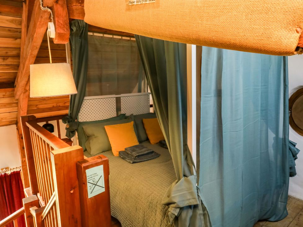 A bedroom with a bed and curtains at Swallows Nest in Widecombe-in-the-Moor near Postbridge