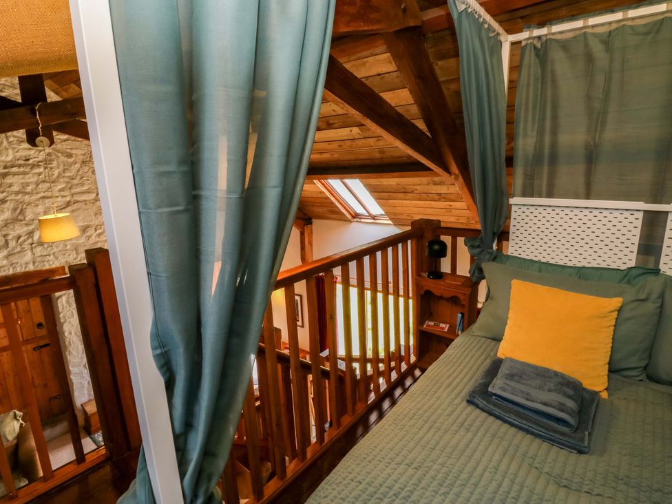 A loft bedroom with a bed and railing at Swallows Nest Widecombe-in-the-Moor near Postbridge