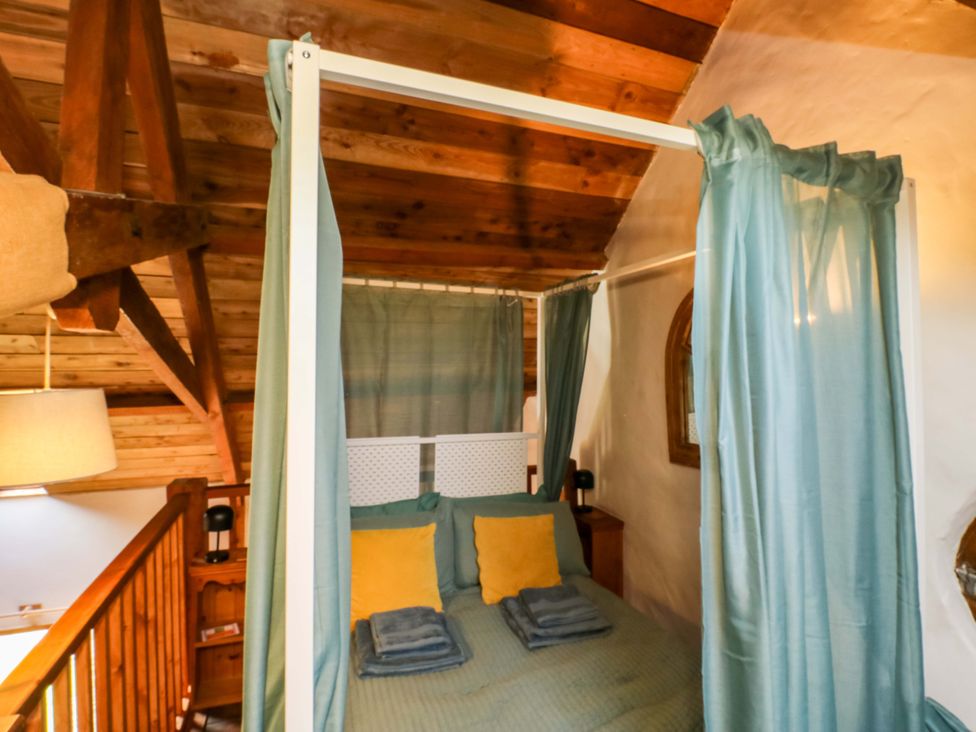 A bedroom with a four-poster bed and wooden ceiling at Swallows Nest Widecombe-in-the-Moor near Postbridge