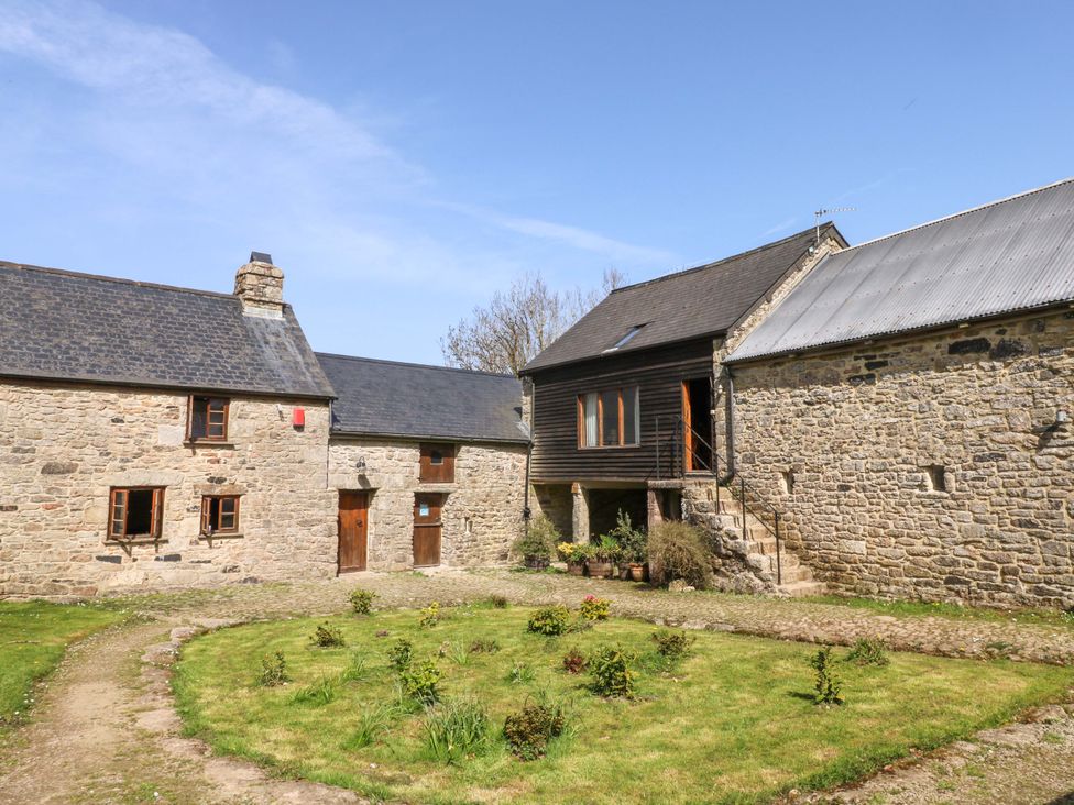 An outdoor area with stone and wooden houses at Swallows Nest in Widecombe-in-the-Moor near Postbridge