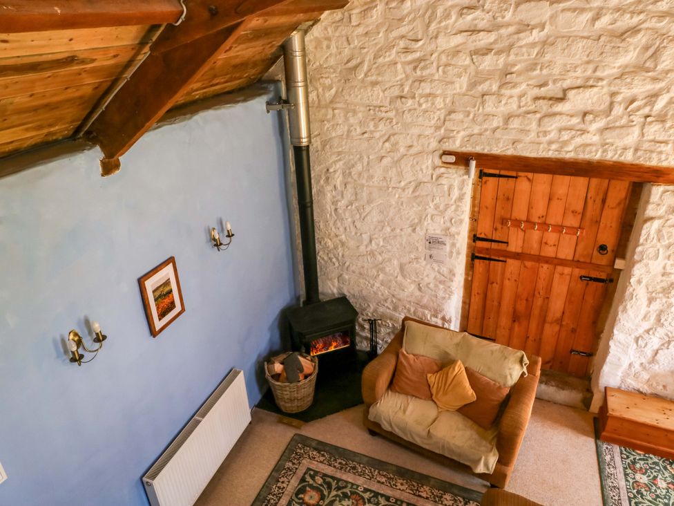 A living room with a fireplace and sofa at Swallows Nest near Widecombe-in-the-Moor