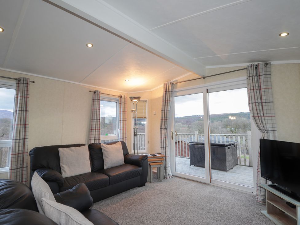 A living room with a sofa and television at Coll in Fort William