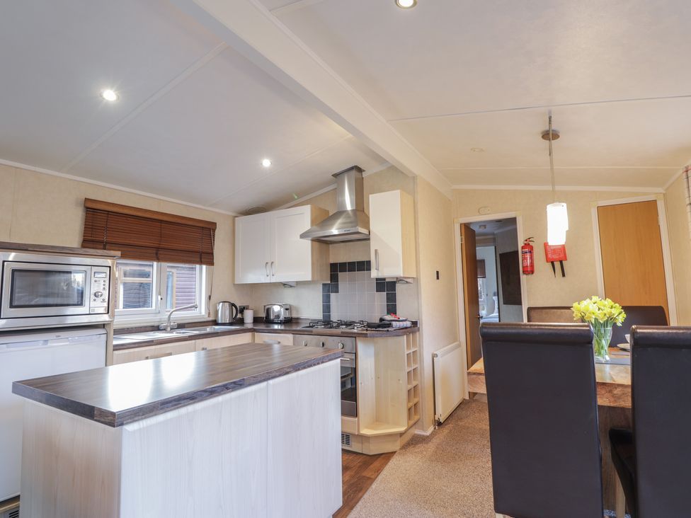 A kitchen with appliances and dining area at Coll in Fort William