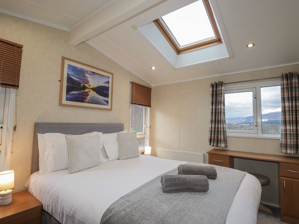 A bedroom with a bed and desk at Coll in Fort William