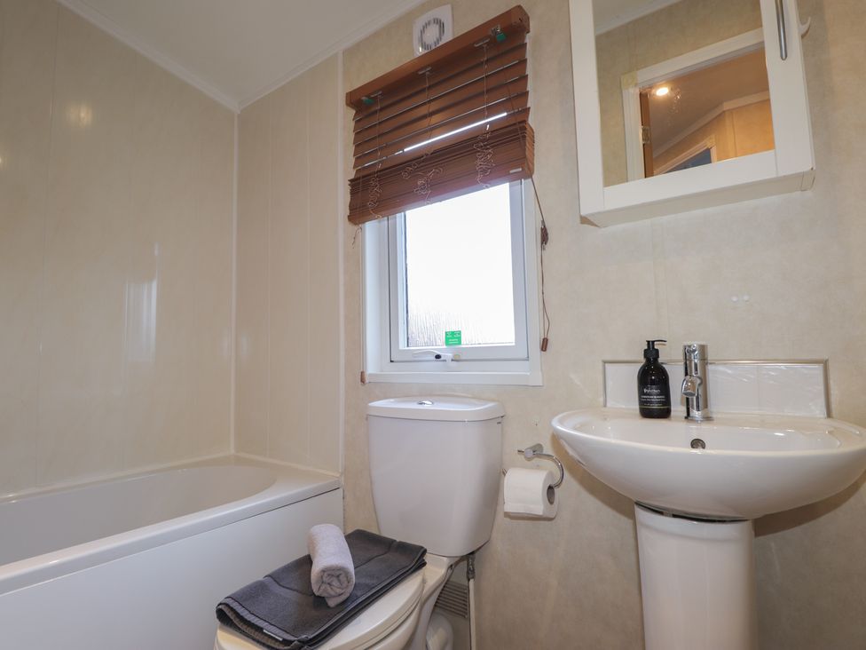 A bathroom with a bathtub, toilet, and sink at Coll in Fort William