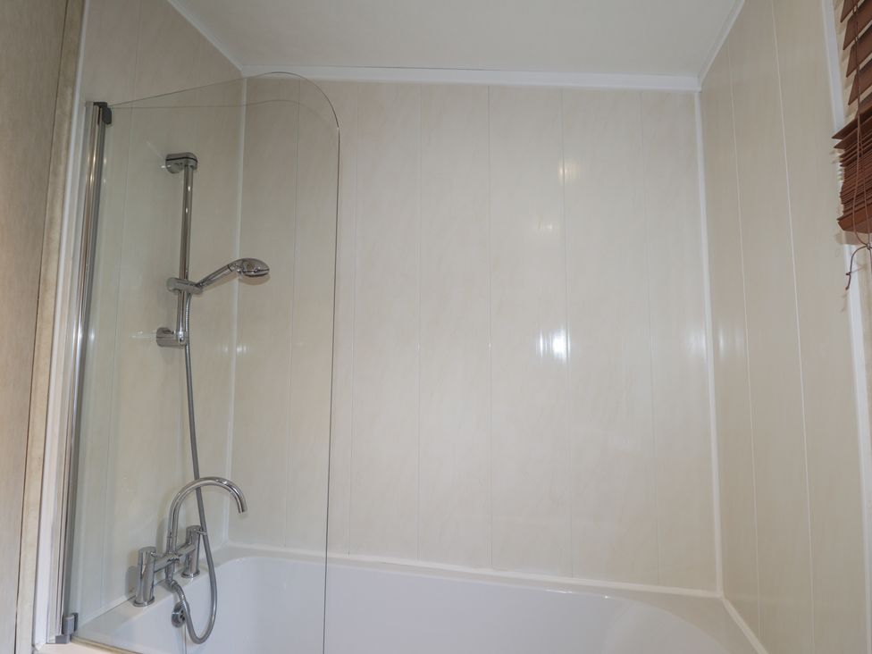A bathroom with a bathtub and showerhead at Coll in Fort William