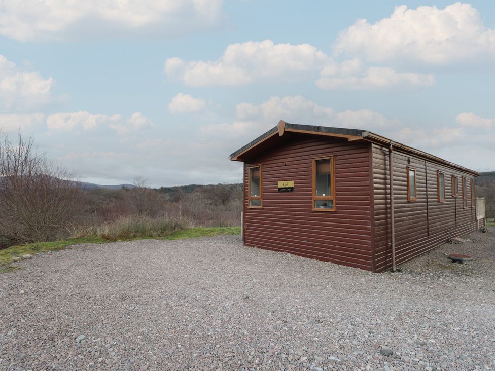 A log cabin with windows and a sign at Coll in Fort William