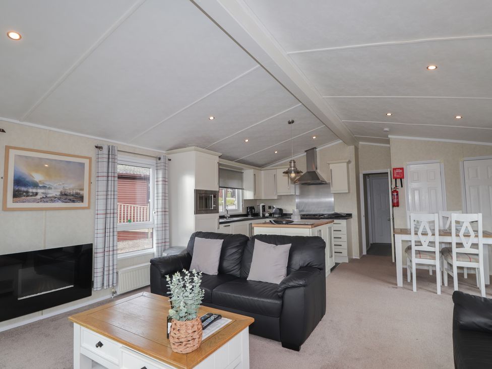 A living room with a sofa and dining area at Monach 2 in Fort William