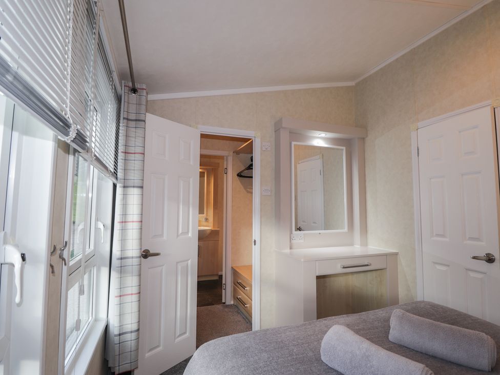 A bedroom with a mirror, closet and window at Monach 2 in Fort William