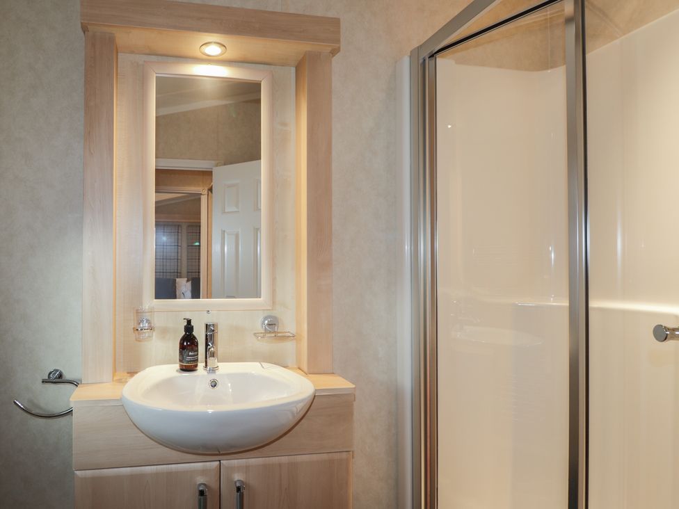 A bathroom with a sink and shower enclosed at Monach 2 in Fort William