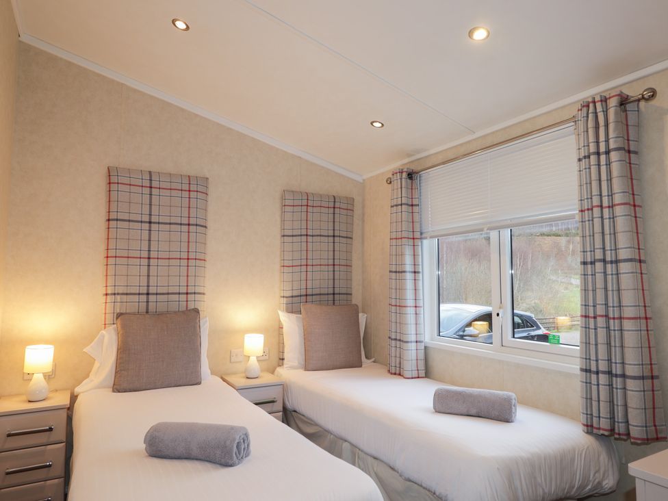 A bedroom with two beds and a window at Monach 2 in Fort William