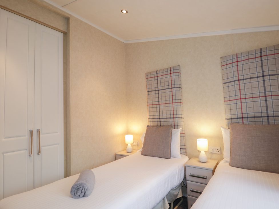 A bedroom with two beds and bedside tables at Monach 2 in Fort William