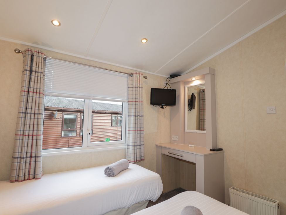 A bedroom with two beds and a television at Monach 2 Fort William