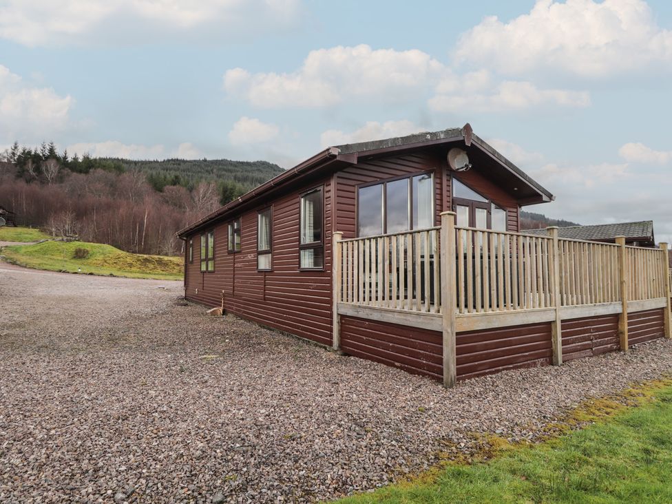 A log cabin with a deck and windows at Monach 2 Fort William