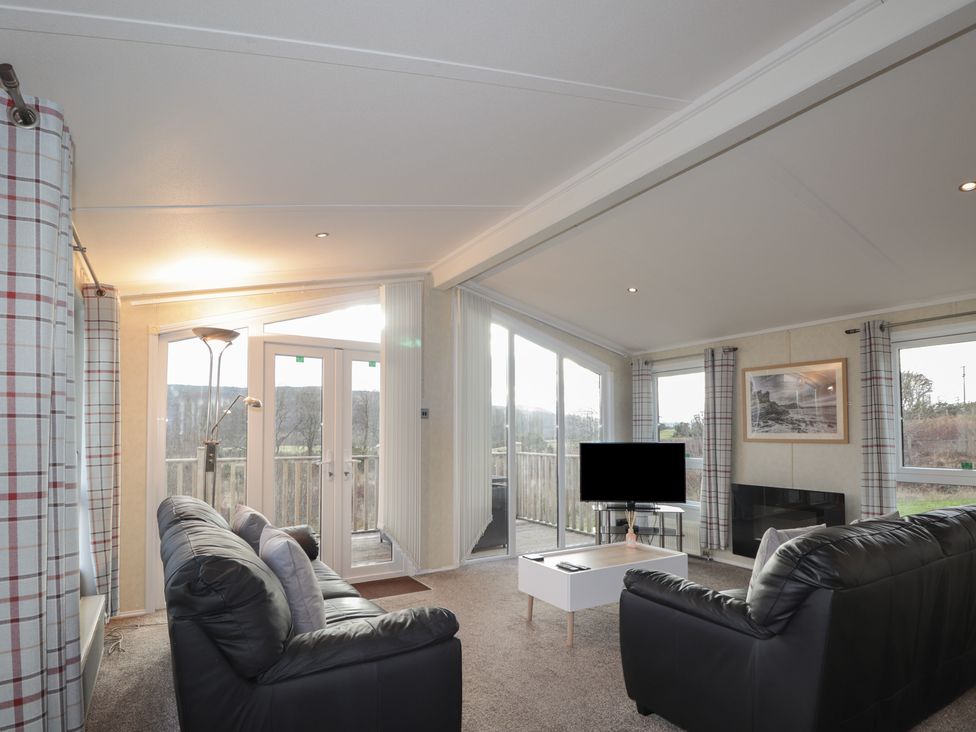 A living room with a television and sofa at Monach 3 in Fort William