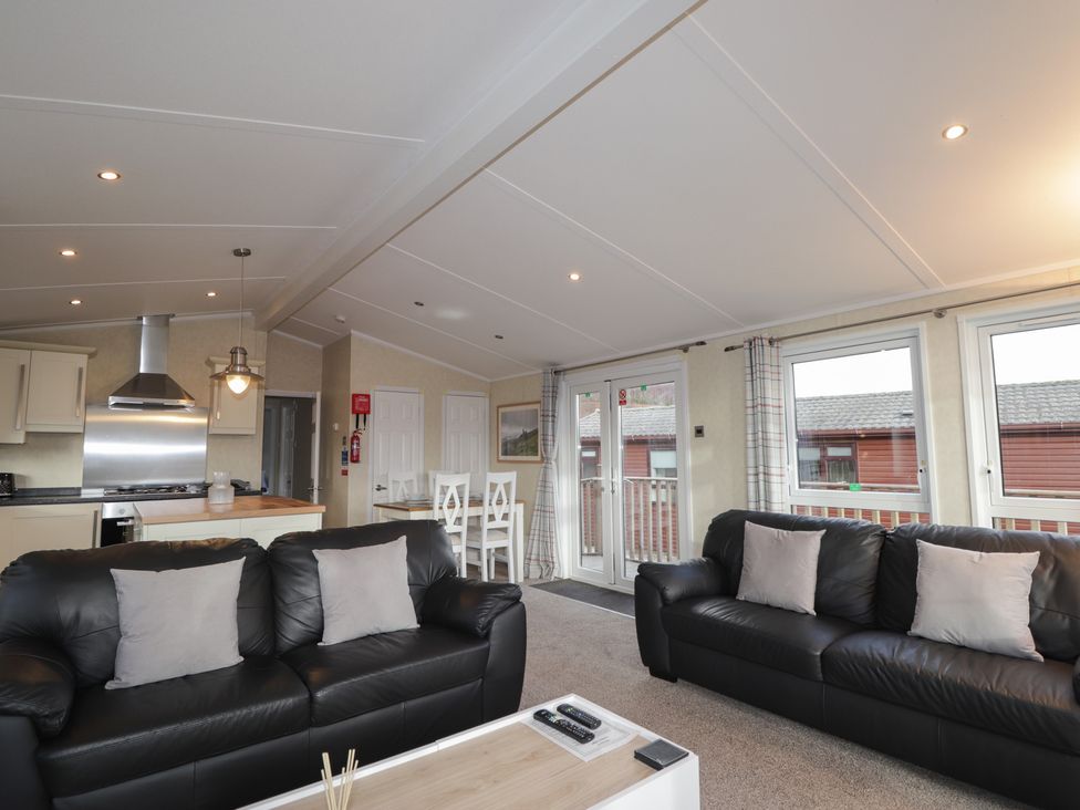 A living room with a sofa and dining table at Monach 3 in Fort William