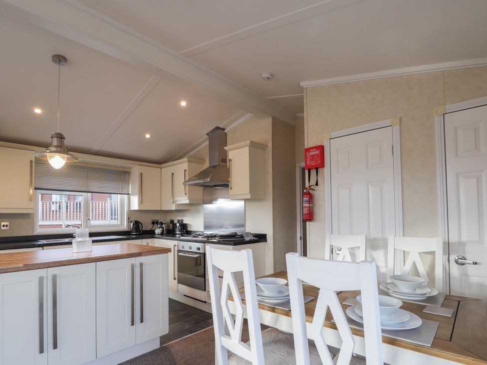 A kitchen with a dining table and appliances at Monach 3 Fort William