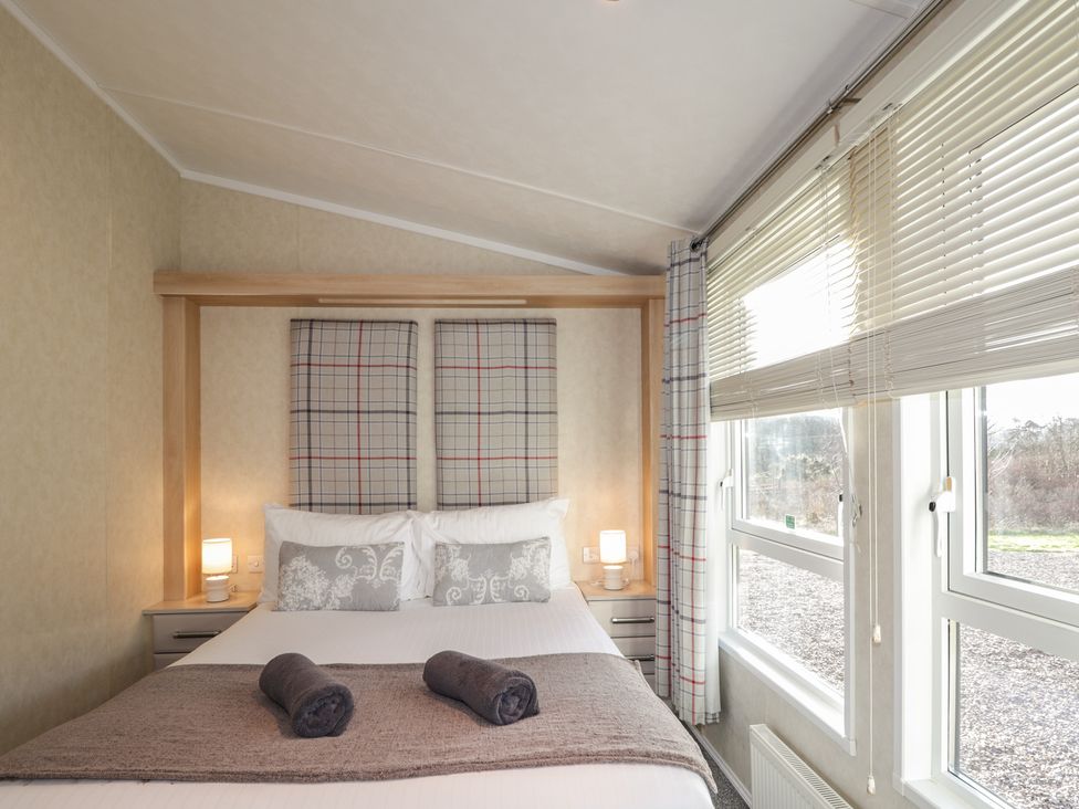 A bedroom with a bed and windows at Monach 3 in Fort William