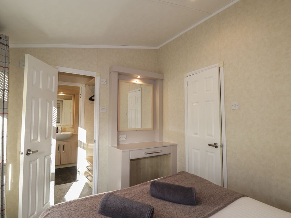 A bedroom with a mirror and dresser at Monach 3 in Fort William