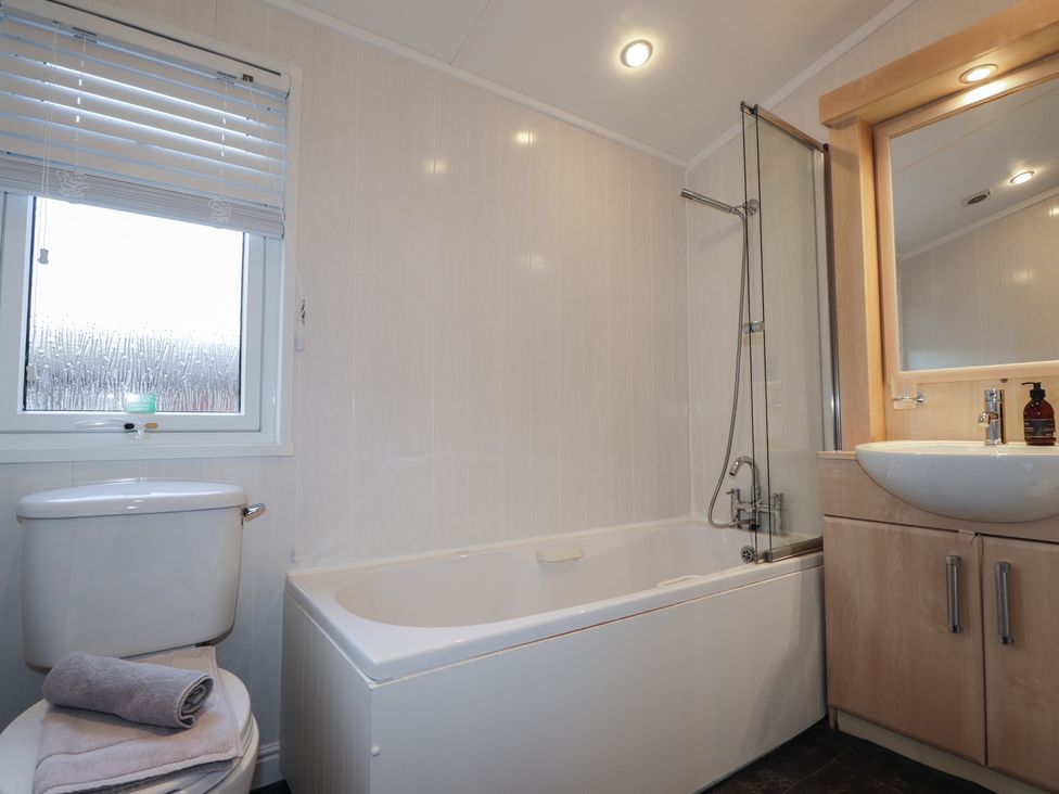A bathroom with a bathtub, toilet, and sink at Monach 3 Fort William