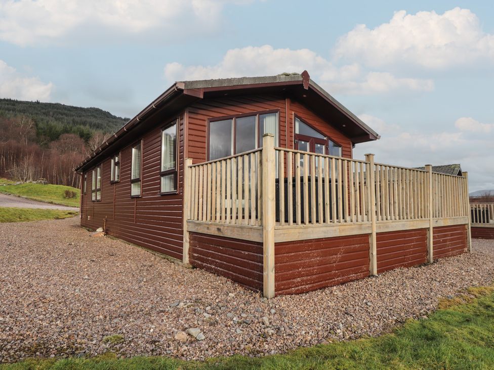 A wooden house with a deck and gravel area at Monach 3 in Fort William