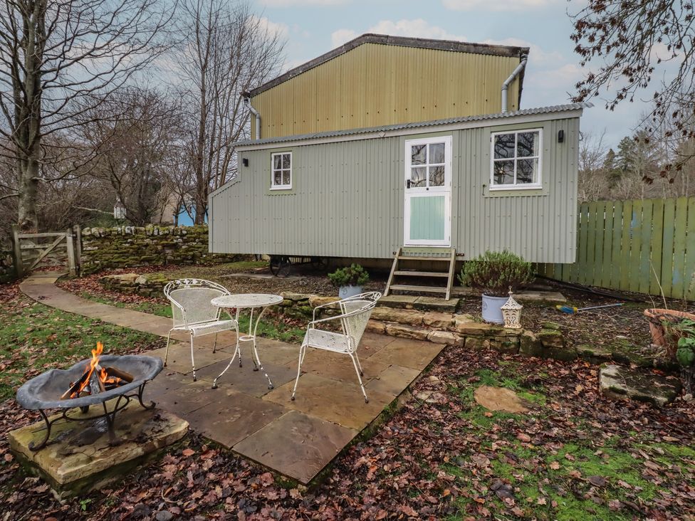 A house with a fire pit and seating area at Woodland in Hexham