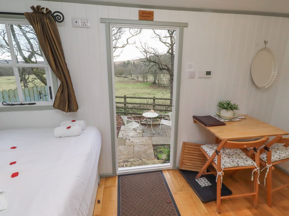 A bedroom with a table and chairs at Woodland in Hexham