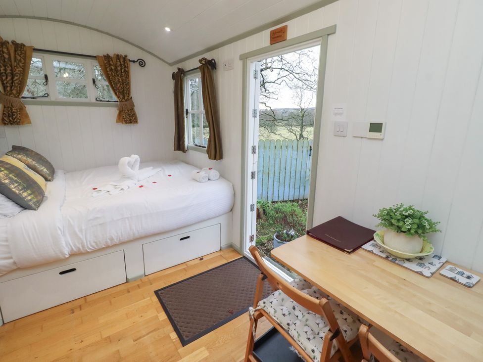 A bedroom with a bed and a table at Woodland in Hexham