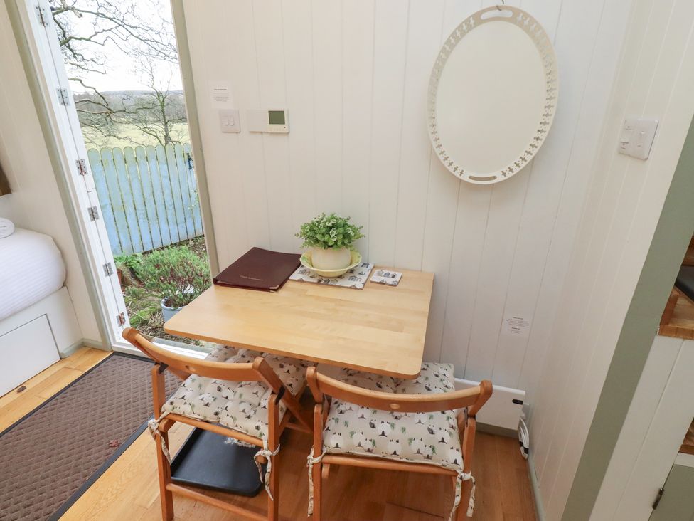 A dining area with a table and chairs at Woodland in Hexham