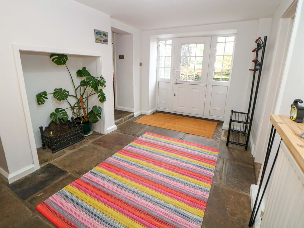 A hallway with a rug and plant at The Farmhouse in High Peak