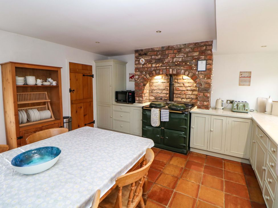 A kitchen with a table and cabinets at The Farmhouse in High Peak