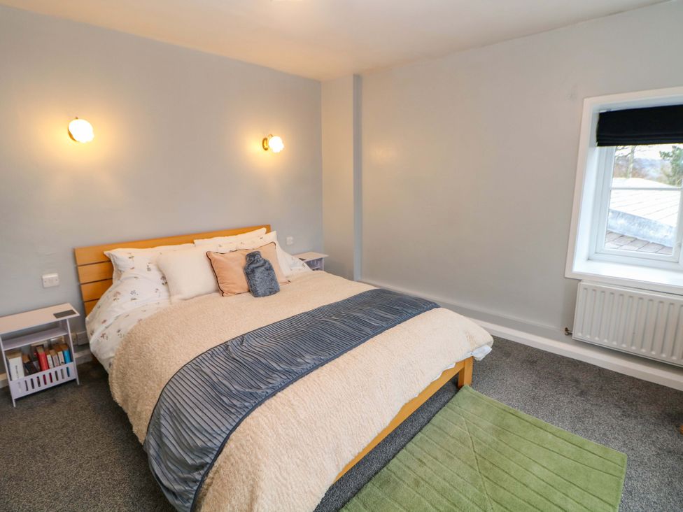 A bedroom with a bed and bedside table at The Farmhouse in High Peak