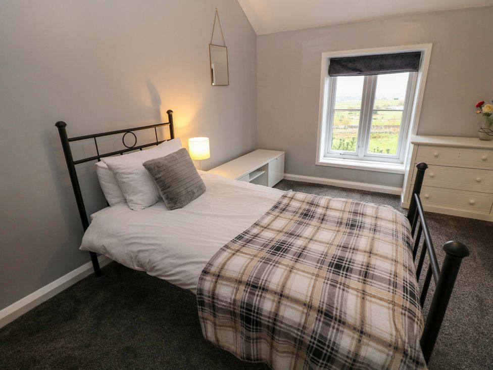 A bedroom with a bed and a dresser at The Farmhouse in High Peak