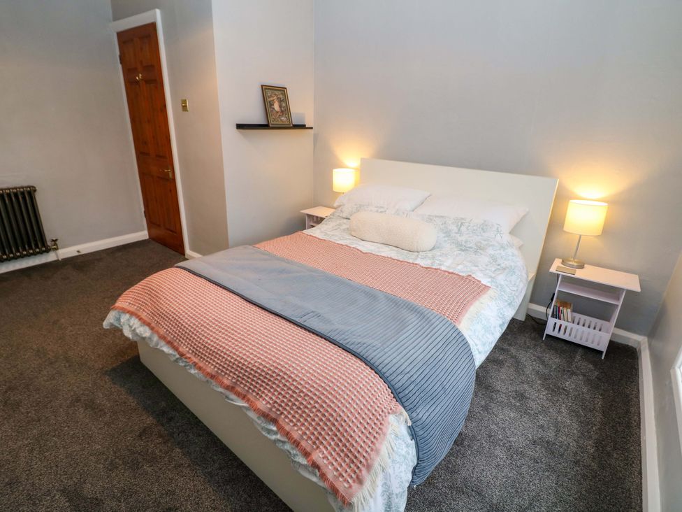 A bedroom with a bed and bedside lamps at The Farmhouse in High Peak