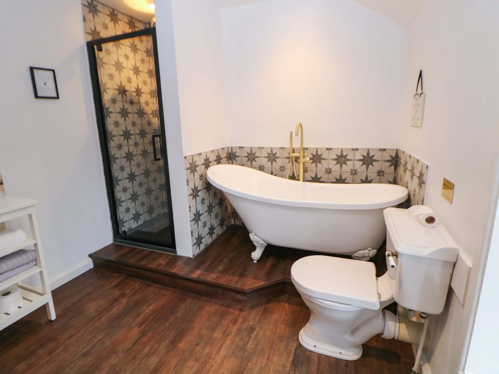 A bathroom with a bathtub and shower at The Farmhouse in High Peak