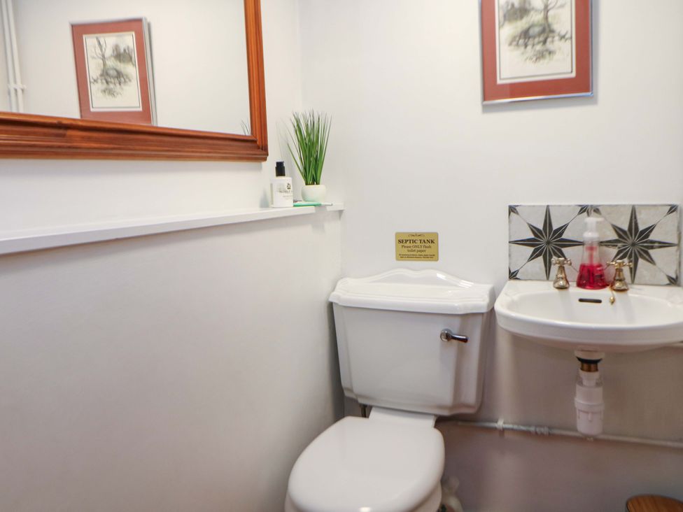 A bathroom with a toilet and sink at The Farmhouse in High Peak